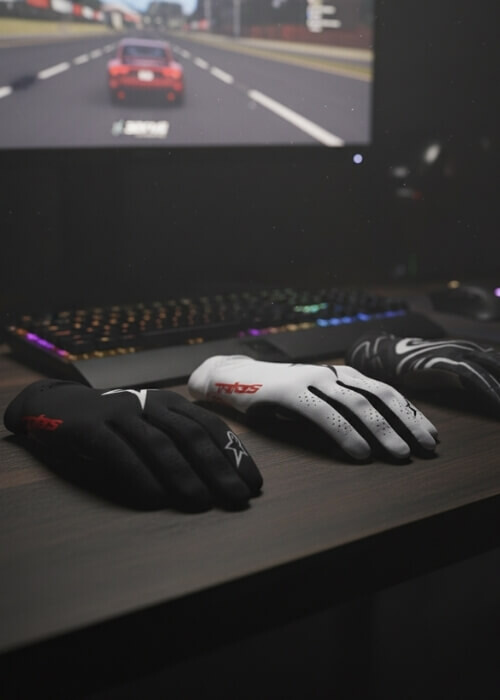 Alpinestars SimRacing Handschuhe nebeneinander auf Tisch