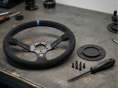 SimRaceShop Lenkrad neben Zubehör auf Tisch liegend